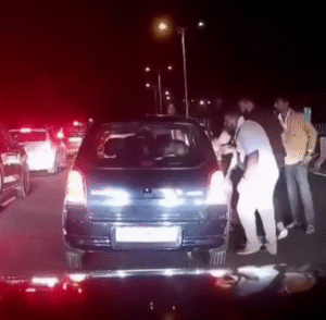 A screen capture orientation or illustrative visual of a highway road rage incident with a car stopped on an expressway and people arguing.
